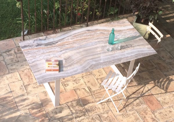 Vue de dessus de la table à manger de jardin avec plateau en céramique effet marbre onyx et pied modèle Apogée blanc uni