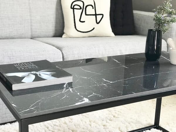 Table basse de salon rectangulaire avec plateau en céramique effet marbre noir et pied en métal noir de style minimaliste