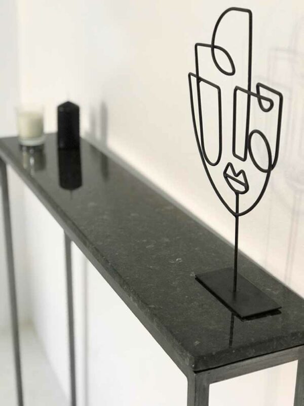 console d'entrée étroite avec plateau en marbre granit noir et pied en acier fin et minimaliste.