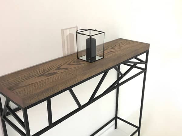 La console design KAYLEE est dotée d'un plateau en bois massif personnalisable et d'un pied en métal au design graphique unique et exclusif.