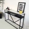 console moderne avec plateau en marbre blanc et pied en métal noir avec étagère.