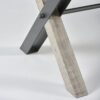 Détail du pied en forme de Croix alliant bois et métal, finition foncée gris Forest.