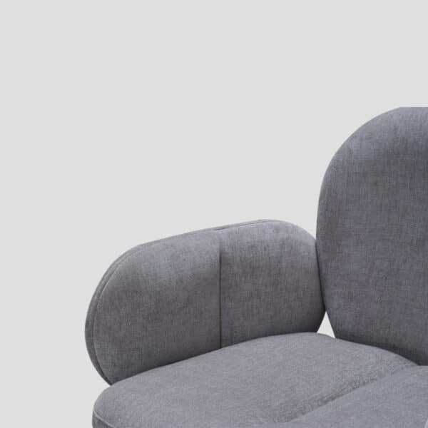 Détail de l'accoudoir et de l'assise en tissu gris du fauteuil de table