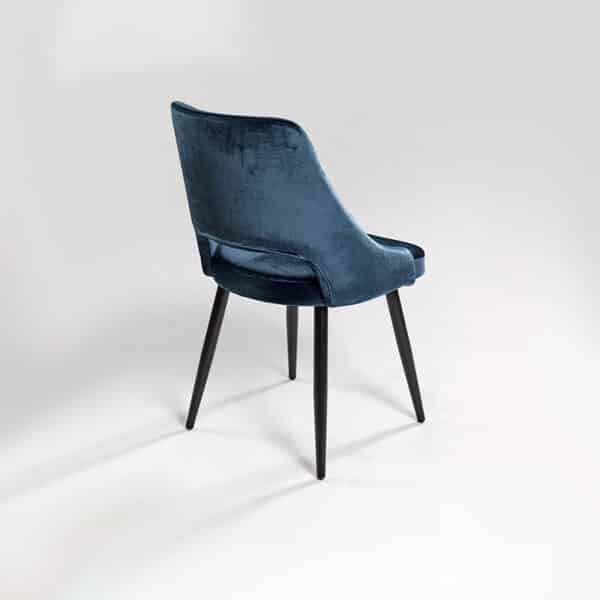 chaise de table moderne avec dossier arrondi enveloppant en velours bleu. Vue de dos