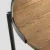 détail du plateau rond en bois naturel et du haut du piétement en métal noir.