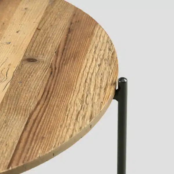 Détail du plateau et du haut du piétement en métal noir de la table basse ronde bois métal industrielle