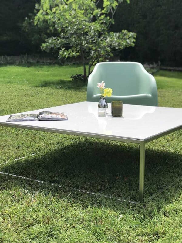 table basse de salon de jardin avec plateau en céramique blanche et piétement en inox au design fin, minimaliste et élégant.