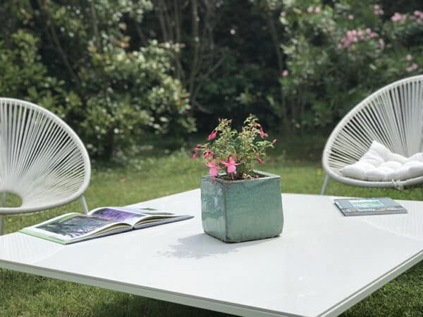 Zoom sur le plateau en céramique italienne haut de gamme, couleur blanche. Pied design en aluminium laqué blanc.