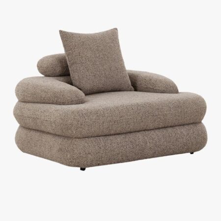 Fauteuil confortable de salon en tissu bouclé de grande qualité de couleur Sable mouillé, avec formes arrondies, accoudoirs, repose nuque et coussin intégré. pour un confort optimal. Vue de trois-quarts.