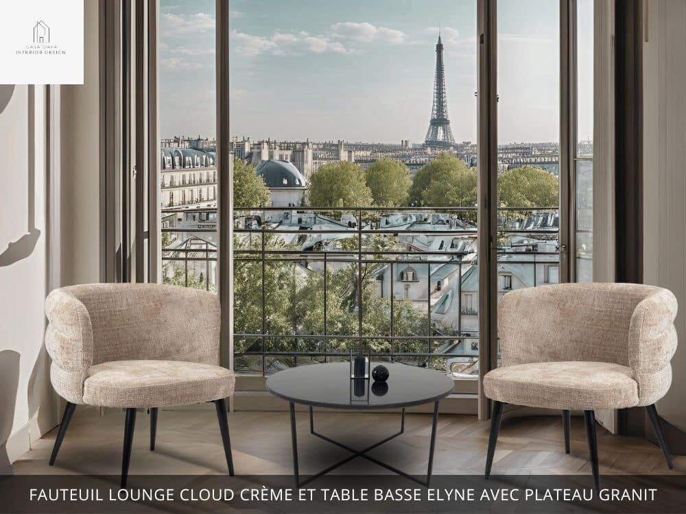 Salon séjour ouvert par une fenêtre sur la ville de Paris avec la tour Eiffel avec, au premier plan, 2 fauteuils confortables en tissu beige CLOUD LOUNGE CREME et la table basse ronde ELYNE avec plateau en granit noir et pied en métal noir croisé.