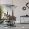 Intérieur finement décoré avec un tableau représentant Notre Dame de Paris, la chaise confortable WAVE avec dossier arrondi en tissu Taupe et la console design KELYA C en métal gris anthracite avec plateau en céramique au choix.