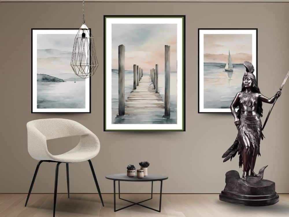 Hall d'entrée décoré avec la chaise au design moderne en tissu blanc perle WHALE BLANC PERLE, la table basse ronde en marbre noir ELYNE, statue en bronze de la guerrière Indienne et 3 aquarelles au mur représentant des paysages marins.