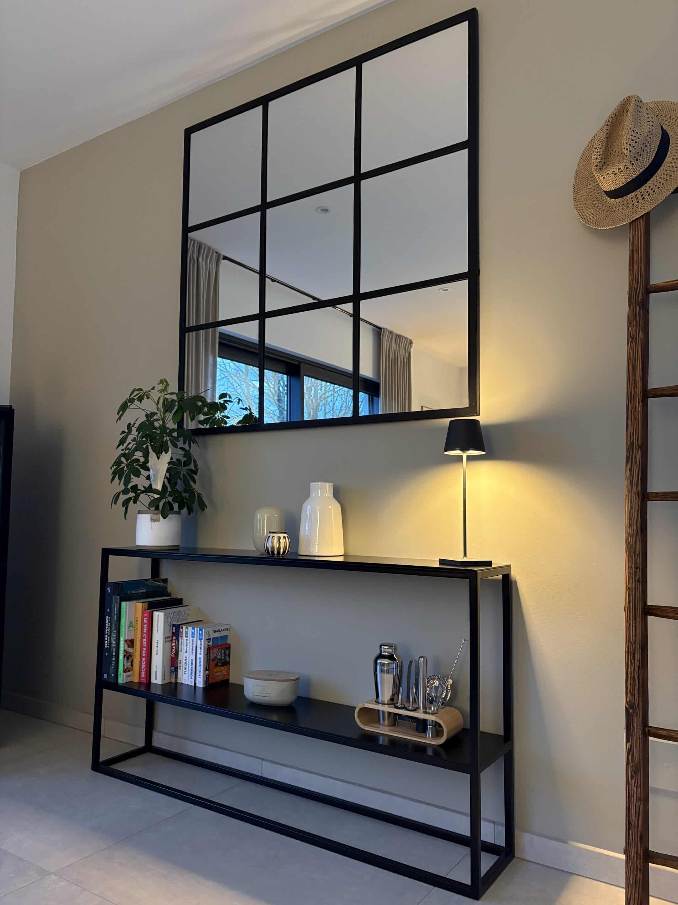 Dans cette entrée, la console chic Juliette en métal noir impose son élégance graphique. Elle s’accompagne d’un miroir aux contours métalliques, dont l’armature de style industriel chic dialogue subtilement avec la rigueur du meuble.